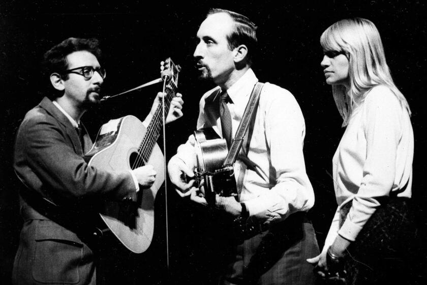 American folk trio Peter, Paul and Mary are shown during rehearsals at the London Palladium, Nov. 8, 1965, for the Royal Variety Performance in front of Queen Elizabeth II and Prince Philip. From left to right: Paul Stookey, Peter Yarrow, and Mary Travers (AP Photo/Bob Dear)