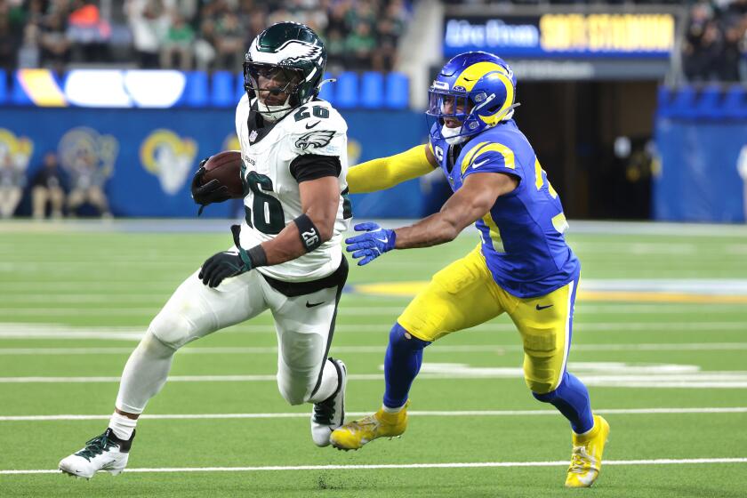 Eagles running back Saquon Barkley picks up yards against Rams safety Quentin Lake in the third quarter at SoFi Stadium