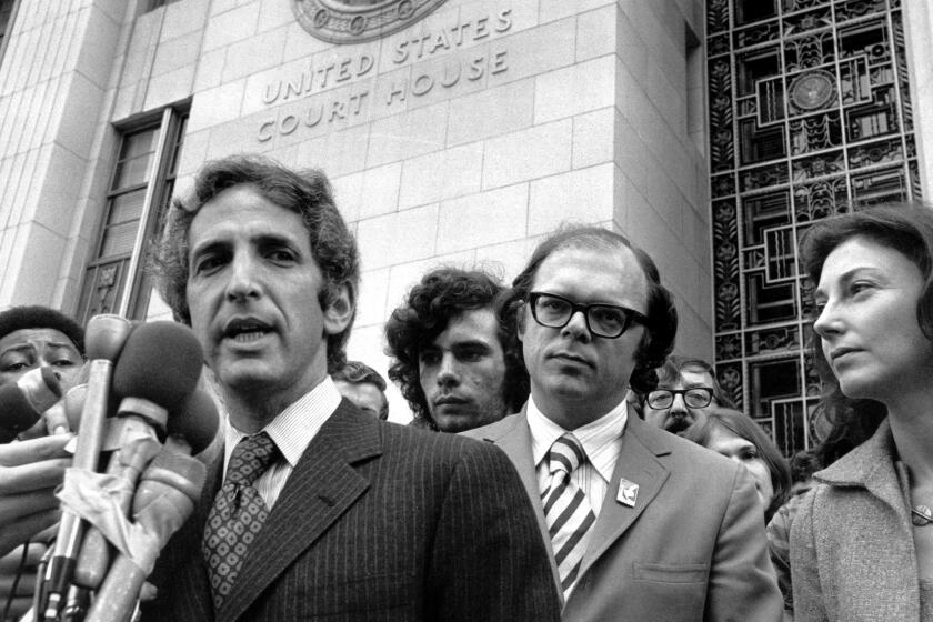 As his co-defendant, Anthony Russo (right) listens, Daniel Ellsberg tells newsmen outside the Federal Building in Los Angeles, Ca. on Jan. 17 1973 that the Pentagon Papers trial prosecuters were acting out "their contempt for the American people" by placing a movie screen between the trial principals and the press and public, seated at the back of the courtroom. The Judge ordered the screen removed and replaced by a smaller one along the wall. (AP Photo/stf)