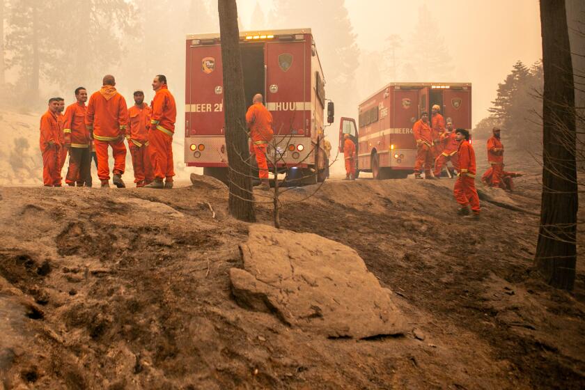 STRAWBERRY, CA - AUGUST 27: Incarcerated firefighters from Eel River Conservation Camp continue to tackle the Caldor Fire as the fire's footprint continues to expand southwest of the Lake Tahoe Basin on Friday, Aug. 27, 2021 in Strawberry, CA. (Jason Armond / Los Angeles Times)