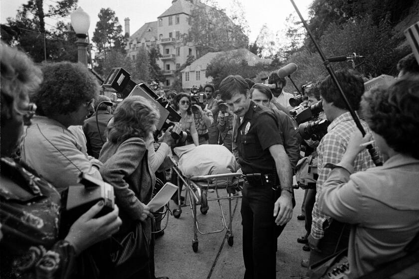 Officials remove the body of actor-comedian John Belushi from a bungalow at the Chateau Marmont hotel in Los Angeles, Ca., where Belushi's body was found dead, Friday, March 5, 1982. Belushi, 33, died of an accidental drug overdose. (AP Photo/Lennox McLendon)