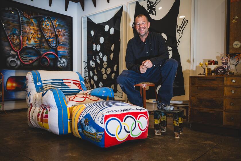 Los Angeles, CA - October 14: Artist Darren Romanelli in his studio with an Olympic themed version of his signature upcycled patchwork lounge chair and ottoman on Monday, Oct. 14, 2024 in Los Angeles, CA. (Jason Armond / Los Angeles Times)