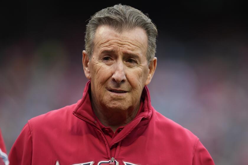 Arte Moreno, owner of the Los Angeles Angels, stands on the field before a baseball game