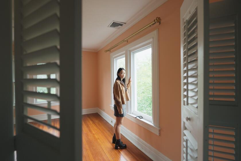 A young woman stares into a closet.