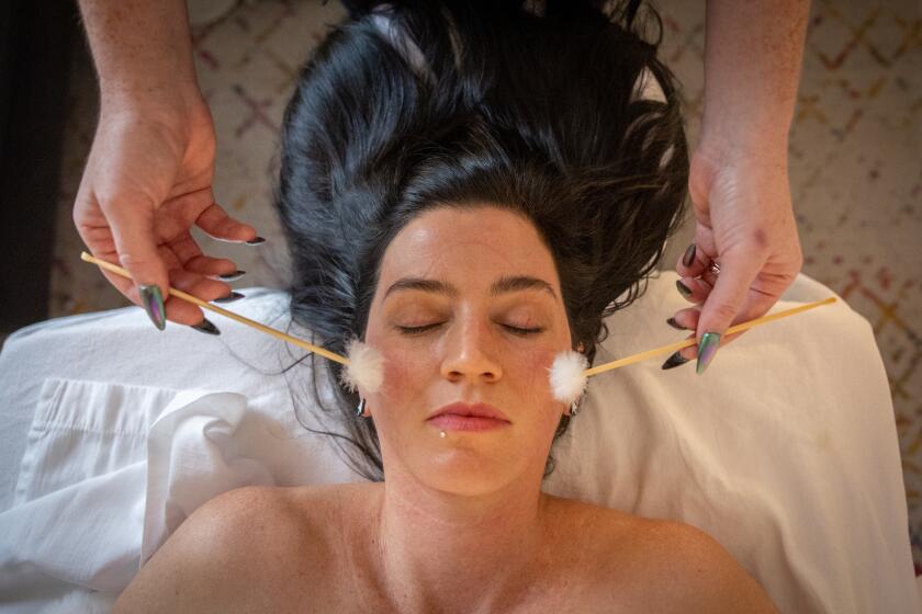 Pasadena, CA - December 11: Julie Luther an ASMR masseuse gives Jackie Snow a massage on Wednesday, Dec. 11, 2024 in Pasadena, CA. (Jason Armond / Los Angeles Times)