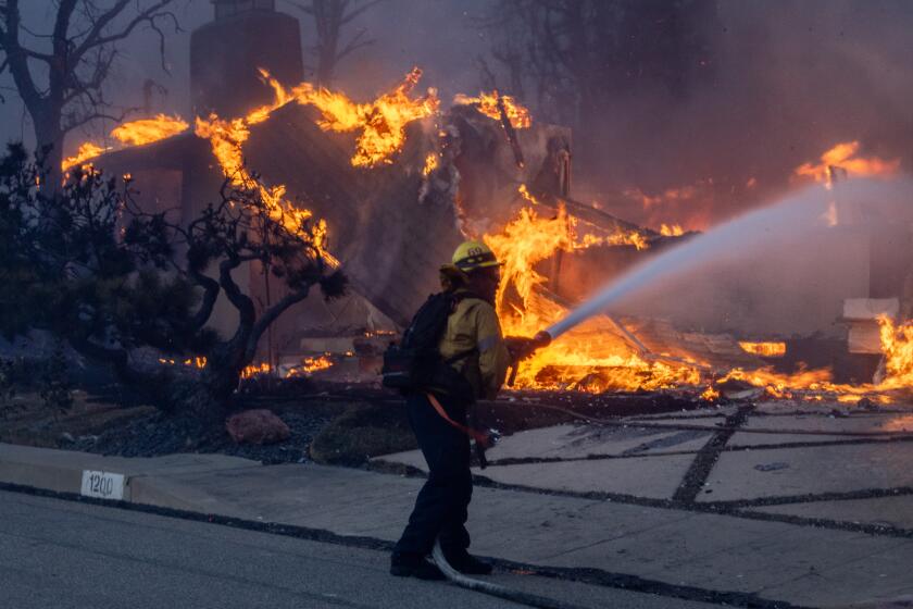 Pacific Palisades, CA - January 07: Firefighters battle the Palisades fire on El Medio Ave. on Tuesday, Jan. 7, 2025 in Pacific Palisades, CA. (Brian van der Brug / Los Angeles Times)