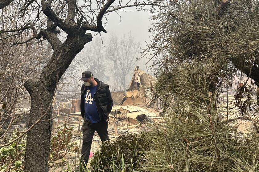 Dean Yasharian walks through what's left of his Altadena home after the Eaton fire burned through his neighborhood. 