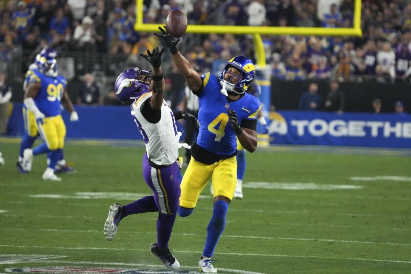 The Rams' Ahkello Witherspoon (4) breaks up a pass intended for the Vikings' Justin Jefferson during their playoff game. 