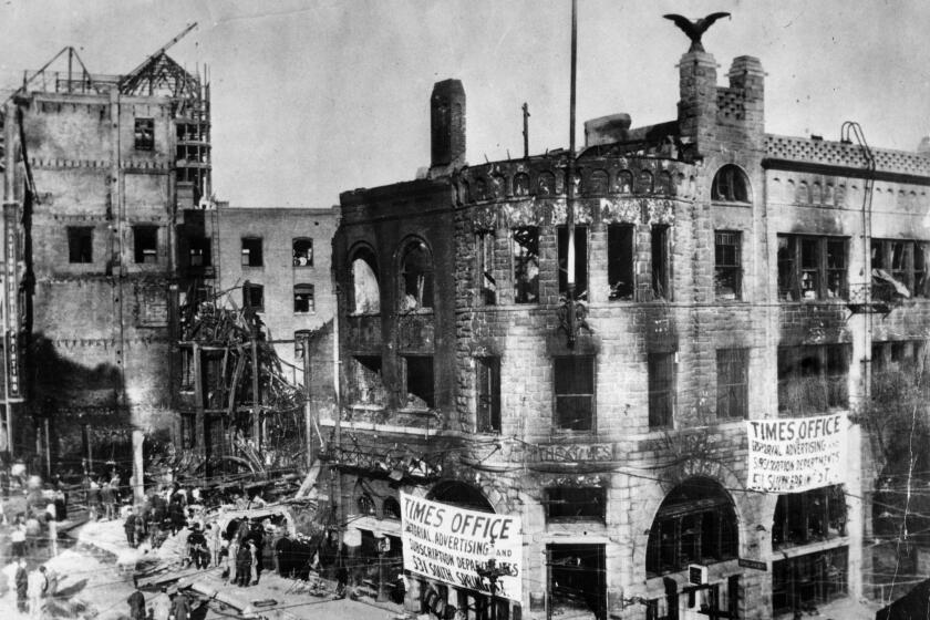 Oct. 1910: The bombed out Los Angeles Times building with poster announcing temporary locations of Times departments. On the back of this photo was written: Following the bombing, the newspaper moved its offices to a branch at 531 S. Spring St. A rival paper offered its presses to that the paper could be printed. In a box on the front page of the Times on Saturday morning Oct. 1, 1910, Harry Andrews, Managing Editor of the the Times wrote: They can kill on men and can wreck out building, but by the God above they cannot kill the Times.