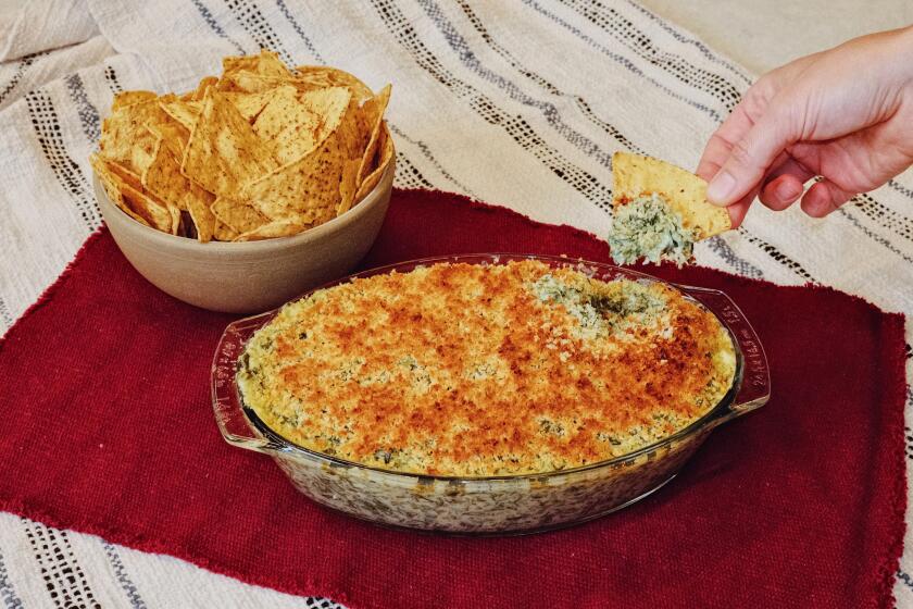 Kismet chefs Sara Kramer and Sarah Hymanson whip up a baked dip packed with cheese, fresh greens and pickles in the L.A. Times Test Kitchen. The recipe can also be found in their 2024 cookbook, "Kismet: Bright, Fresh, Vegetable-Loving Recipes."