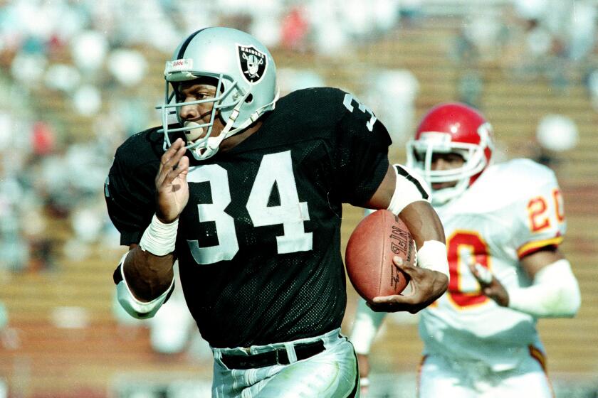 Bo Jackson, the two-sport star and running back for the Los Angeles Raiders, takes off on a 45-yard run against the Kansas City Chiefs, including free safety Deron Cherry (20), early in the fourth quarter of Sunday, October 15, 1989 game at the Coliseum in Los Angeles. (AP Photo/Bob Galbraith)