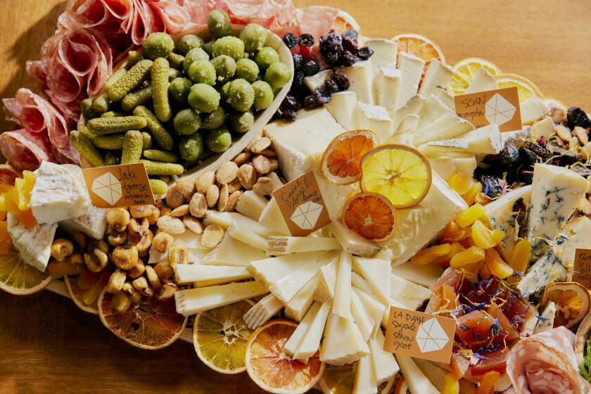 DTLA Cheese Superette's holiday cheese boards can feature a variety of elements, including cheese, olives, cornichons, nuts, dried fruit, meats, and garnished with dehydrated citrus.