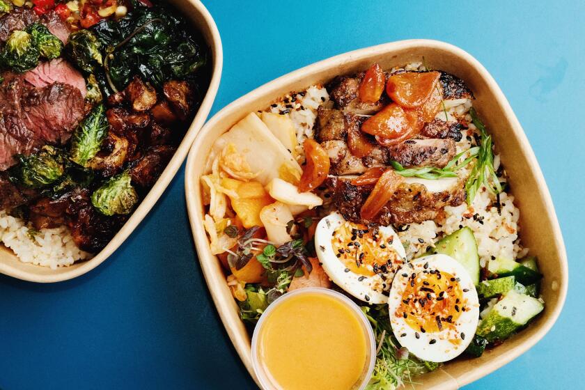 A rice bowl with kimchi, eggs, garlic and chicken with persimmon vinaigrette, and a steak bowl with greens on a blue table