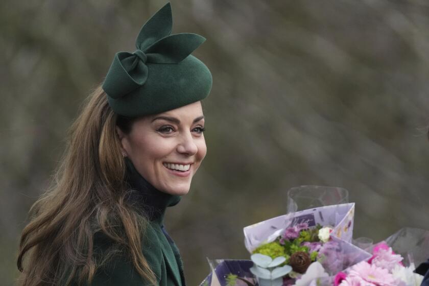 Kate Princess of Wales smiles as holds a bouquet of flowers