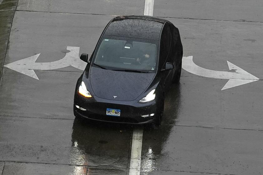 A motorist in a Tesla Model 3 gets a mixed message on which way to turn as a heavy rain pelts the intermountain west early Sunday, May 12, 2024, in Denver. (AP Photo/David Zalubowski)