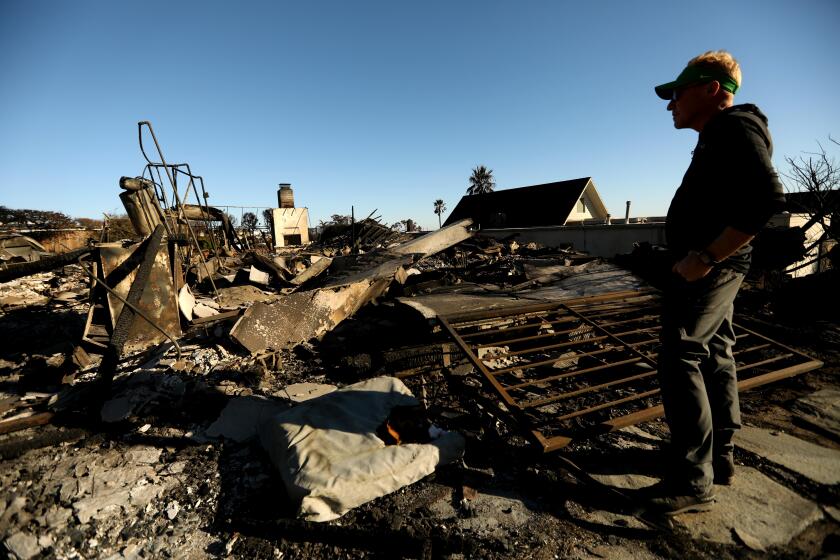 PALISADES, CA - JANUARY 14, 2025 - - Steve Foster, 52, stands in the middle of a home destroyed by the Palisades fire in the Sunset Mesa neighborhood after delivering dog food and supplies to an elderly man who did not evacuate his home in Palisades on January 14, 2025. (Genaro Molina/Los Angeles Times)