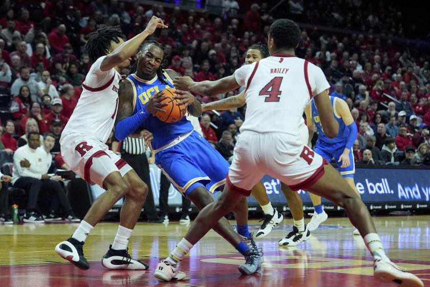 UCLA guard Sebastian Mack, second from left, drives into Rutgers guard Jamichael Davis, left, during the first half of an NCAA college basketball game, Monday, Jan. 13, 2025, in Piscataway, N.J. (AP Photo/Julia Demaree Nikhinson)