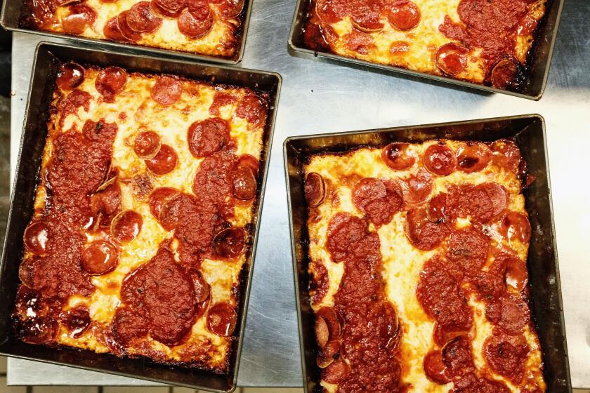 Four cheese-crusted Detroit-style pepperoni pizzas in their pans from Dtown Pizzeria on a counter at the LA Pizza Alliance