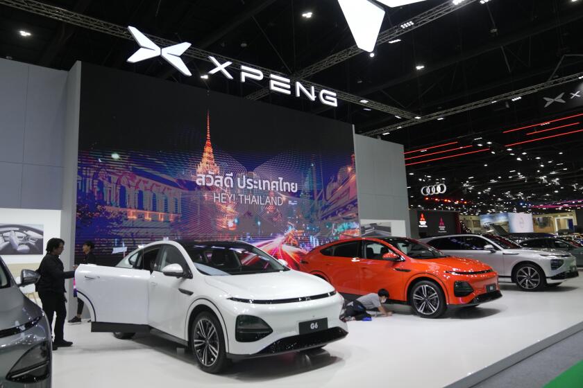 Visitors look at XPENG's electric vehicles during the 45th Bangkok Motor Show in Nonthaburi, Thailand, Tuesday, March 26, 2024. (AP Photo/Sakchai Lalit)