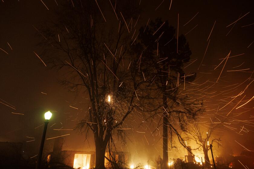 ALTADENA, CA - JANUARY 8, 2025:A wind gust sends burning embers into the air fueling the Eaton after midnight as multiple homes burn on Wooldlyn Road on January 8, 2025 in Altadena, California. (Gina Ferazzi / Los Angeles Times)