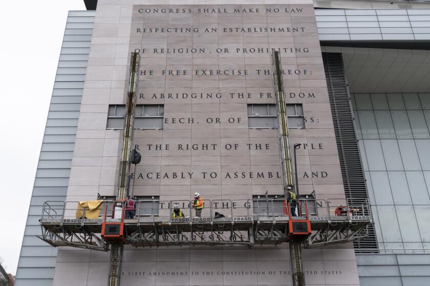 FILE—This file photo from Feb. 12, 2021, workers remove the facade bearing the First Amendment of the U.S. Constitution from what was formerly the Newseum, a private museum dedicated to exploring modern history as told through the eyes of journalists, along Pennsylvania Avenue, in Washington. The façade will be reinstalled at The National Constitution Center in Philadelphia. (AP Photo/Alex Brandon, File)