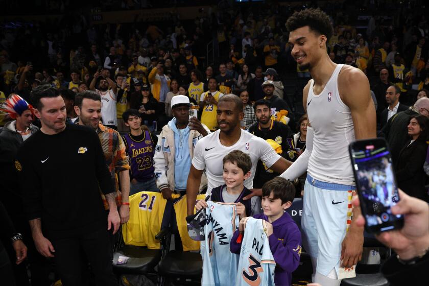 San Antonio Spurs center Victor Wembanyama and guard Chris Paul pose after autographing their jersey with Kai and Knox, children of Los Angeles Lakers head coach JJ Redick after an NBA basketball game Monday, Jan. 13, 2025, in Los Angeles. (AP Photo/Kevork Djansezian)