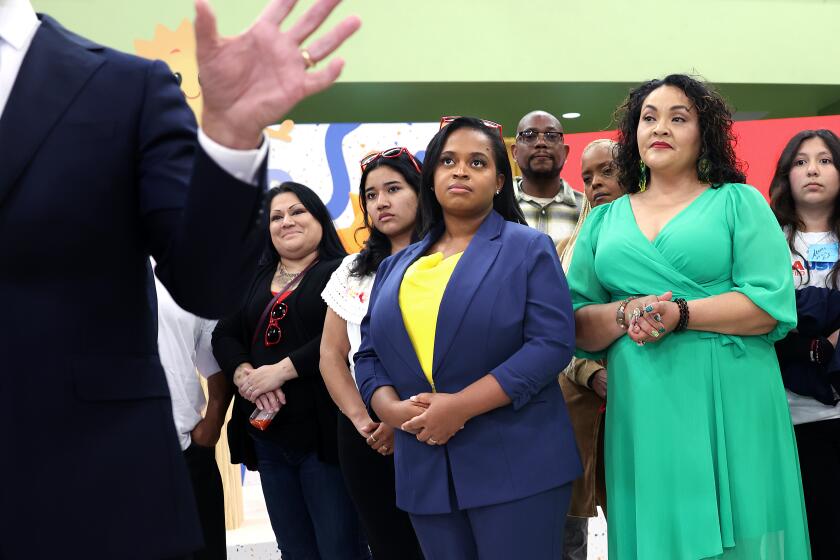 LOS ANGELES-CA-MARCH 20, 2024: Joanna Smith-Griffin, in center wearing blue suit, Founder and CEO of AllHere Education, the company that co-created "Ed," the artificial intelligence chat bot for the Los Angeles Unified School District, listens as Los Angeles Unified Supt. Alberto Carvalho, left, speaks to reporters during the official launch of Ed, at Edward R. Roybal Learning Center in Los Angeles on March 20, 2024. (Christina House / Los Angeles Times)