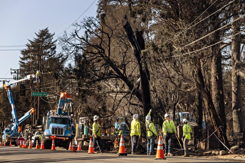 Altadena, CA - January 13: Line crews from PG&E work to fix line in caused by the Eaton fire in Altadena on Monday, Jan. 13, 2025 in Altadena, CA. (Jason Armond / Los Angeles Times)