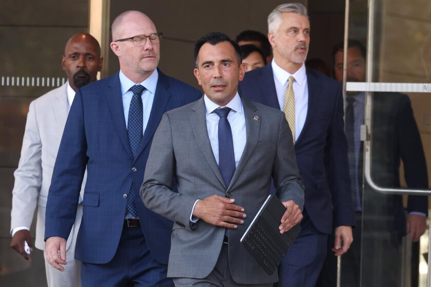 LOS ANGELES CALIF AUGUST 27, 2024 - US attorney E. Martin Estrada, center, exits the downtown federal courthouse in Los Angeles after former high-powered litigator Tom Girardi was convicted in Federal court on Aug. 27, 2024 of running a massive 10-year Ponzi scheme in which prosecutors said he siphoned at least $15 million in settlement funds from four of his clients. (Brian van der Brug / Los Angeles Times)