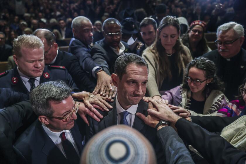 Mayor-elect Daniel Lurie is surrounded by faith leaders who pray for him at synagogue Emanu-el during an interfaith service to honor him ahead of his inauguration in San Francisco on Tuesday, Jan. 7, 2025. (Gabrielle Lurie/San Francisco Chronicle via AP)