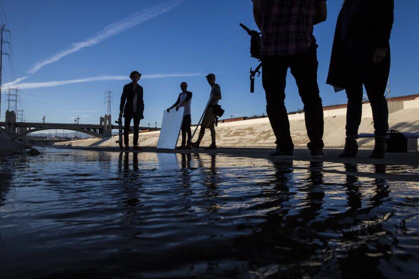 LOS ANGELES, CA - JULY 21: A film crew shoots a fashion commercial along the Los Angeles River on the edge of the Arts District where many film crews and photographers come to use the urban scenery as their backgrounds on Tuesday July 21, 2014. (Jabin Botsford / Los Angeles Times)