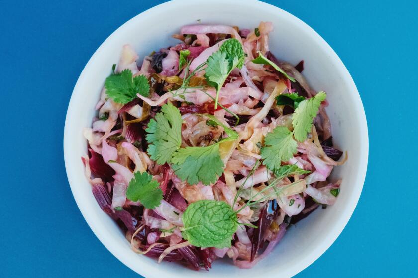 A sauerkraut of cone cabbage, beet stems and herbs at East Hollywood restaurant Fountain Grains & Greens on a blue table